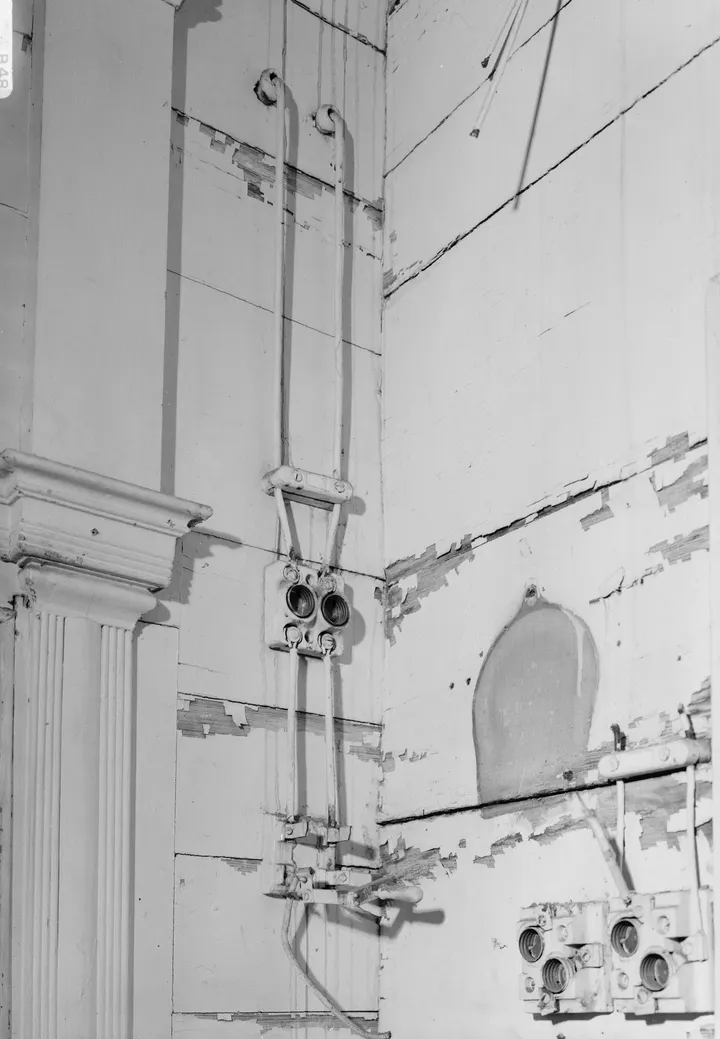 Black-and-white archive photo of early exposed house wiring on porcelain cleats feeding old porcelain fuse blocks