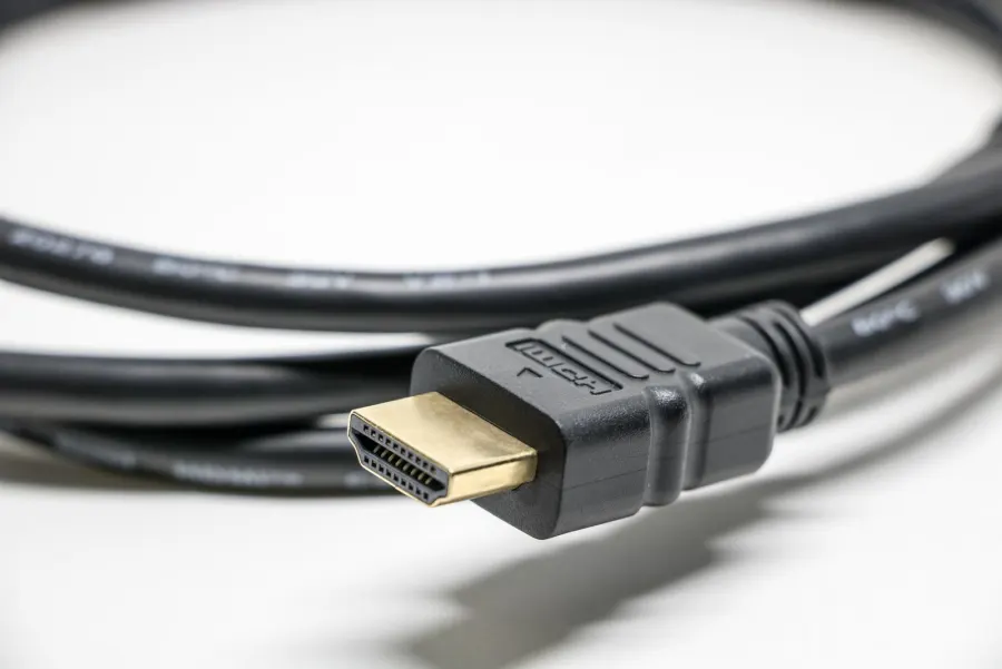 Close-up of a black HDMI cable with a gold-plated plug on a white background
